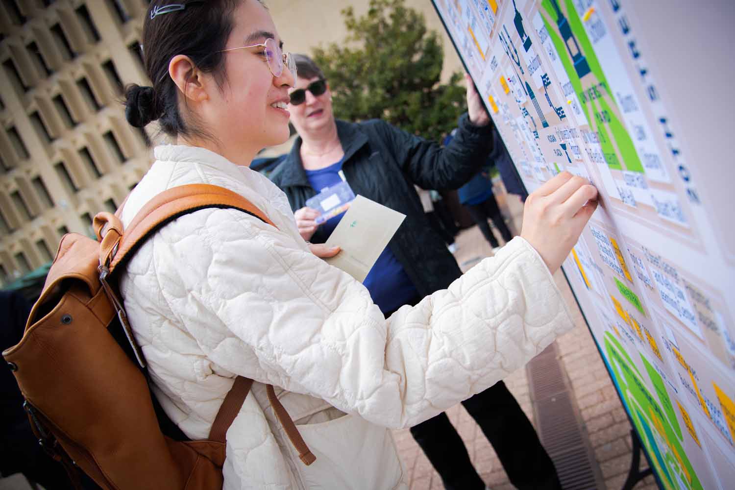 A person signs a wall in Kogan Plaza on Giving Day 2025
