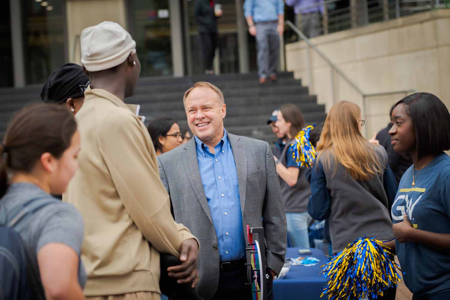 People shake hands in Kogan Plaza on Giving Day 2025