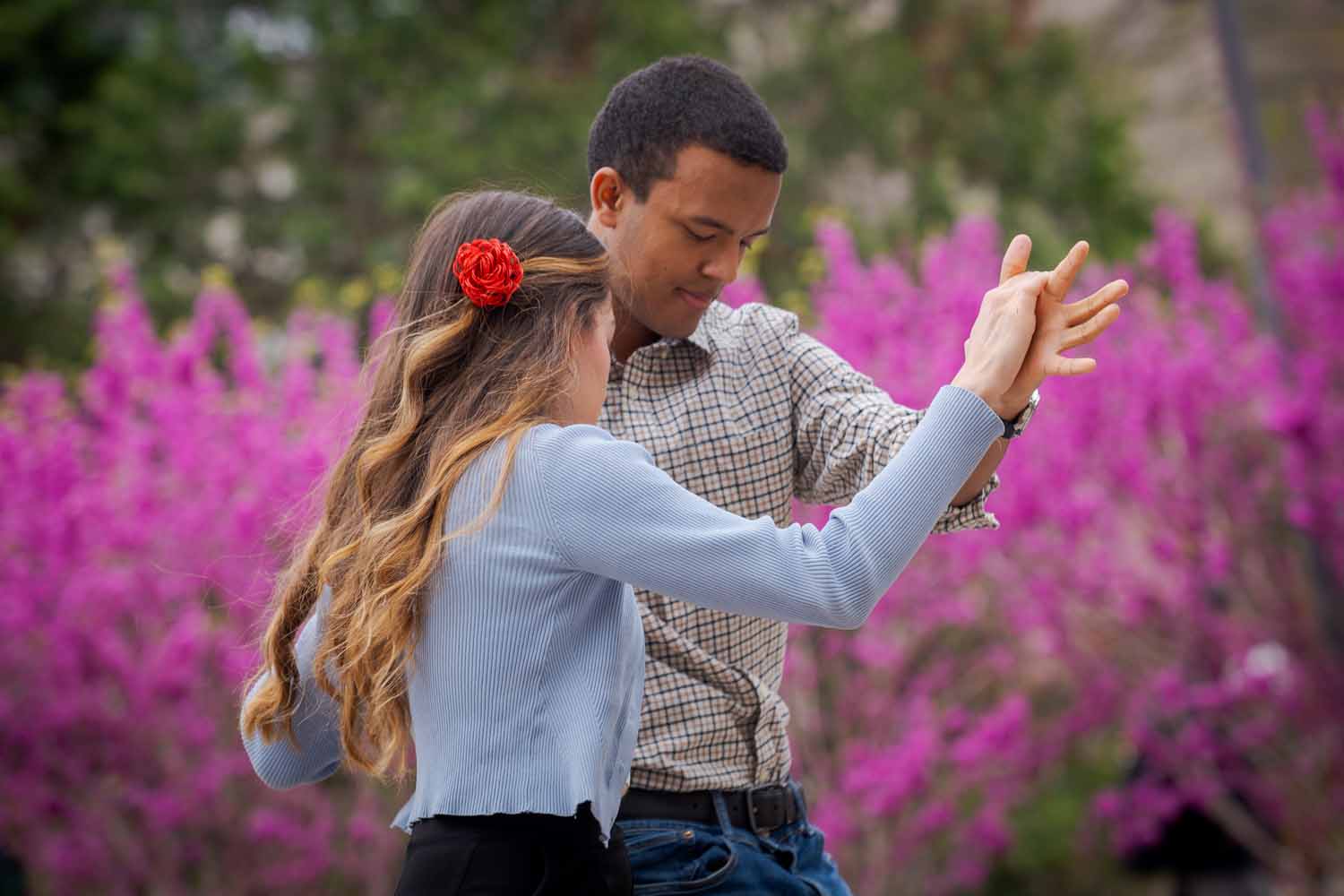 Two people dance in front of pink flowers on Giving Day 2025