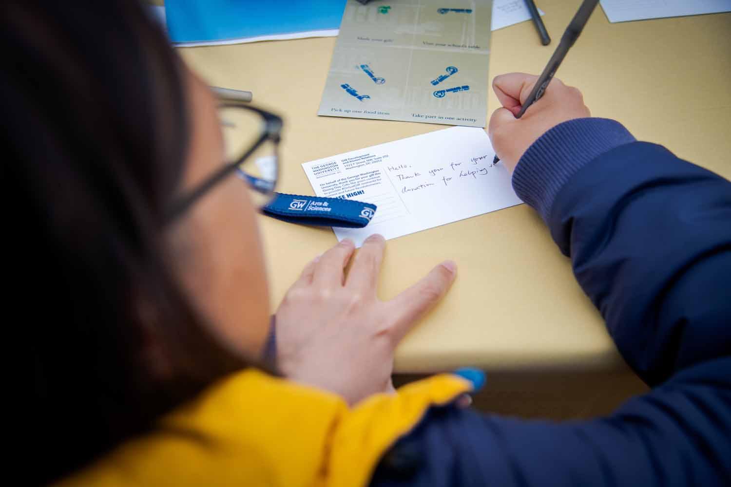 A person signs a card on Giving Day 2025